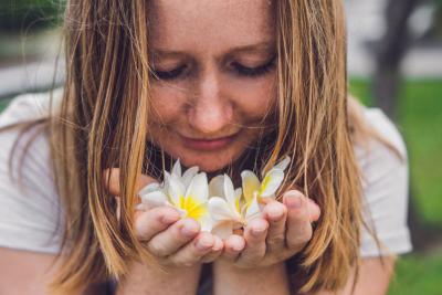 Woman smelling frangipani flowers