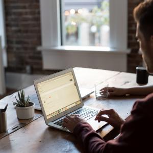 man working at desk with laptop computer